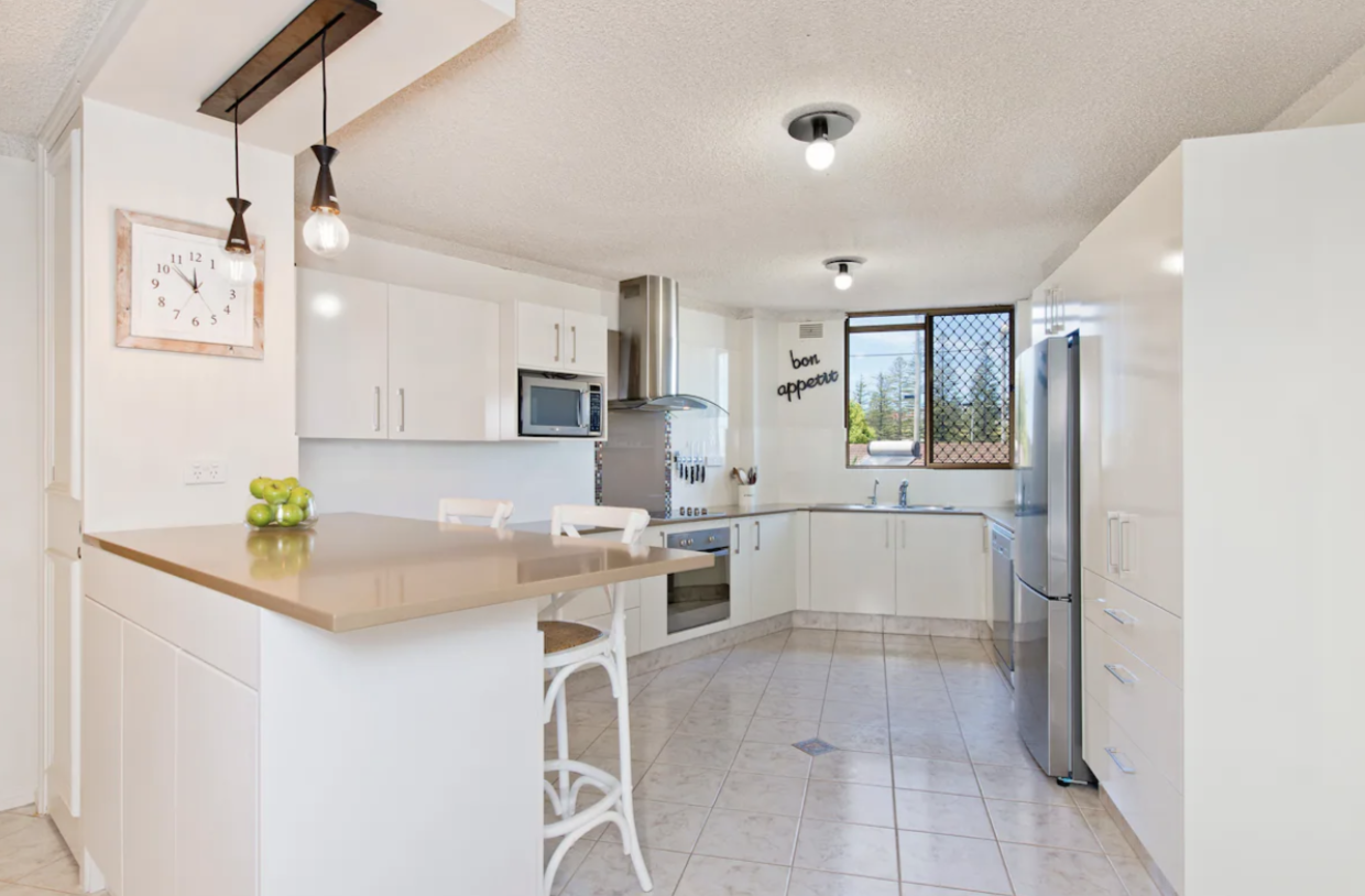 Bright open full kitchen with fridge, oven and dishwasher